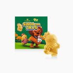 Gold figurine of a lion character from 'Singa dan Tikus' with packaging in the background
